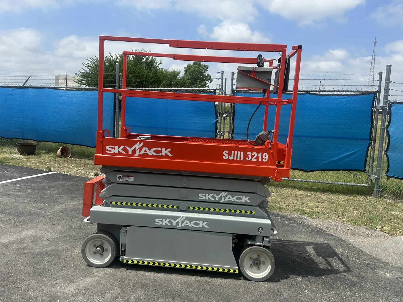 Same scissor lift after refurbishment, with fresh paint and new decals